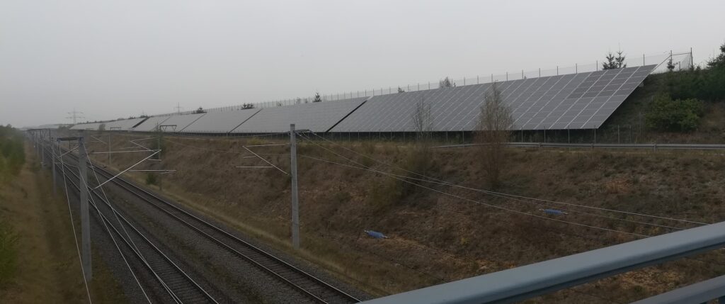 Photo of solar panels aligning fossil fuel transportation infrastructure near the Hambach forest