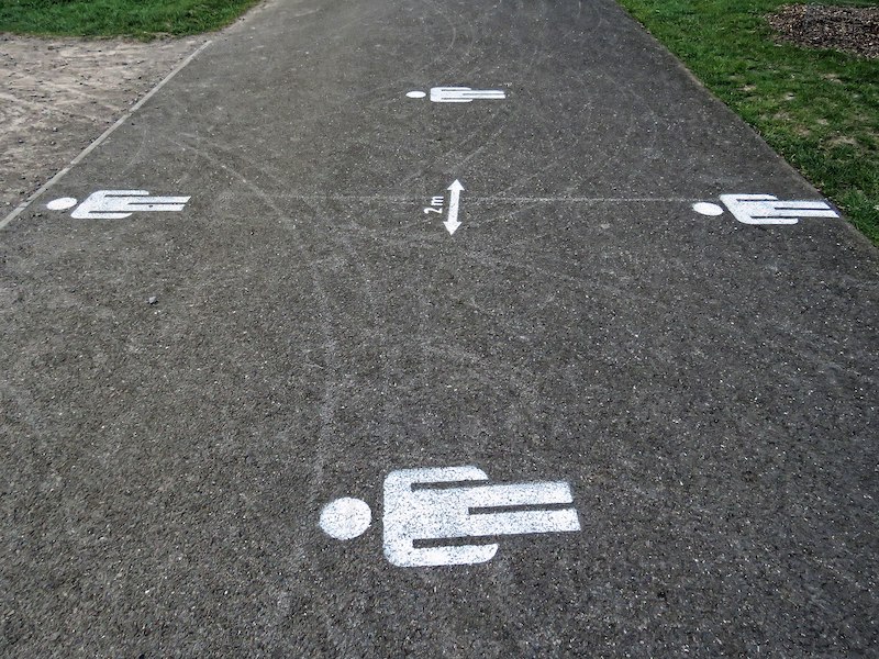 Human figures drawn on ground with an arrow indicating a distance between.